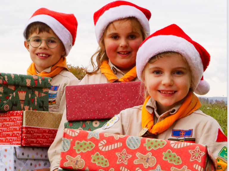Drei Pfadfinder halten Weihnachtsgeschenke Drei Pfadfinder halten Weihnachtsgeschenke